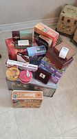 Overview of all items stacked together showing boxes of games and puzzles plus tins