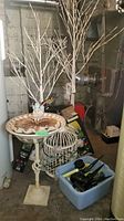 Overall view showing bird bath, faux trees, birdcage, and plastic tub with gardening stakes and lights
