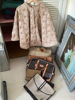 Beaded evening jacket hanging above four handbags and purses on floor