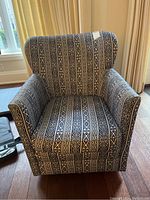 Front view of the patterned Elte armchair showing the upholstery and shape.
