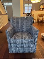 Front view of blue and white patterned Elte armchair with cushioned seat and armrests.