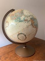 Full view of vintage globe on metal base, showing geographic detail and the metal stand.