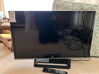 Front view of the 37-inch LG TV showing screen and stand with power cord.