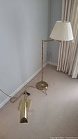 Overview of floor lamp standing upright and desk lamp lying on carpet