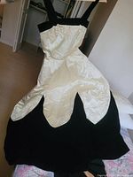White satin bodice with gold-tone embroidery and scalloped overlay on black velvet A-line skirt