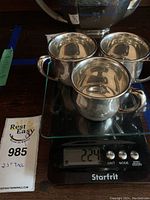Three sterling silver cups on digital scale showing 224 grams