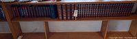 Bookshelf with bound encyclopedias and additional hardcover books