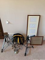 Wide view of lot with tripods, Nikon backpack, picture frames, and metal photo tree