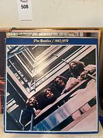 Vinyl record album cover of The Beatles 1967-1970 compilation showing the band leaning over a stairwell