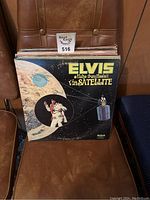 Elvis Aloha From Hawaii Via Satellite vinyl record album front cover on a brown chair.