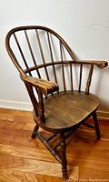 Side view of the antique Victorian continuous arm Windsor chair showing the seating, armrest, and backrest design.