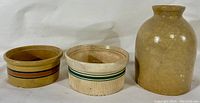 Three pieces: two yellowware crocks with banded decoration and one unmarked stoneware jug