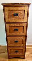 Front view showing four drawers and brass drop-pull handles