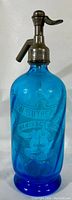 Full view of cobalt blue glass seltzer bottle with metal siphon head