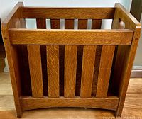 Front view showing vertical slatted sides and curved bottom rail