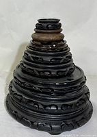 Side view showing tiered design and carved wood details on largest stand