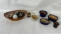 Overall view of the lot showing pottery planters and basket with three carved eggs and small marbles