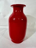 Front view of vintage red flambe porcelain vase with glossy hot lava red glaze on heavy porcelain body.