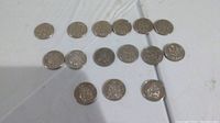 Photo showing all 15 Canadian fifty cent coins arranged in rows on a flat surface.