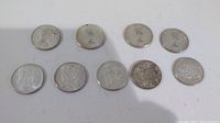 Nine Canadian silver 50 cent coins arranged in two rows showing obverse and reverse sides with heads of Queen Elizabeth II and Canadian crest.