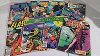 Photo showing 9 DC Comics including Batman, Flash, Green Lantern, Weird Mystery with a rip and hole on cover