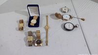 Full view of all 8 watches including 3 pocket watches and 5 wrist watches