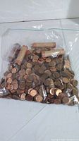 Large resealable plastic bag containing over 1100 circulated pennies and 4 rolls of wrapped pennies