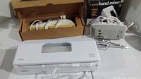 Photo showing Salton vacuum sealer, hand mixer and electric cutter with cords, equipment in used condition with normal wear and marks.