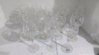 Set of 12 crystal wine glasses arranged together showing pinwheel cut designs and clear stems.
