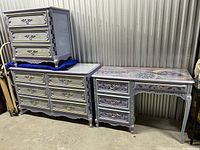 Two matching dressers and hand painted desk arranged together showing painted floral and swirl designs