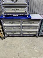 Photo of the front of the hand painted dresser showing all seven drawers and ornate detailing.