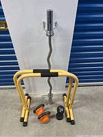 Curl barbell, yellow push-up bars, kettlebells and dumbbell on floor