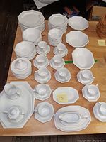 Full view of the ironstone set showing plates, bowls, cups, saucers, and serving pieces spread on a table.