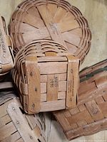 Photo showing the bottom of a signed Longaberger basket with inscription 'MDD 1990' on the wooden base.