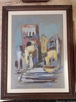 Front view of framed village scape acrylic painting featuring buildings and stairs in pastel colors.
