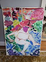 Front view of large canvas painting showing reclining nude figure amidst colorful abstract shapes and floral motifs
