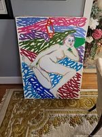 Front view of large canvas painting showing a nude female figure in a colorful abstract background.