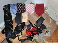 Full view of 15 men's neckwear items including 11 ties and 4 bow ties on a glass table.