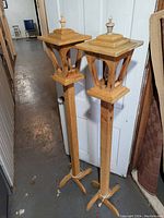 Pair of wooden floor lamp posts standing side by side, showing full height, design, and base.