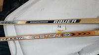 Photo showing Bauer 3000 and Easton Classic branding on the hockey sticks' shafts.