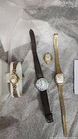 Wide view of the four watches together; three Timex and one Bulova, showing different band conditions.