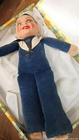 Full view of Jolly Boy Sailor Doll lying flat showing navy blue sailor suit and white sailor cap.
