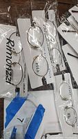 Clear oval kids glasses frames in plastic packaging attached to white display cards labeled with model info and 'Rimonzzi' brand name.