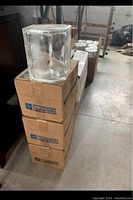 Boxes stacked with a clear glass block on top showing rectangular shape and slight distortion in glass texture.