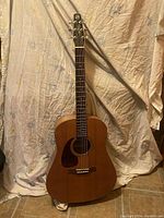 Front view of left-handed dreadnought guitar showing body, pickguard, fretboard