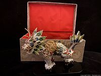Vintage Cloisonné Chinese Dragon figurine posed in front of fabric-lined box with traditional designs, detailing colorful enamel and gold accents on dragon body and base.