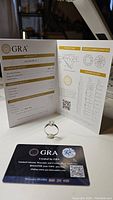 Ring displayed in front of open GRA certificate and card