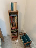 Narrow wooden bookshelf filled with vintage books, showing many hardcover books of various sizes and colors with evident aged wear.