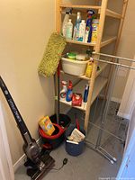 Photo showing Roomie SlimVac upright vacuum, mop, buckets and drying rack in a corner.