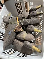 All five duck decoys tied together with bamboo duck call in white plastic basket